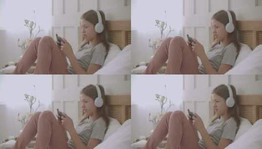 女孩在床上玩手机游戏高清在线视频素材下载