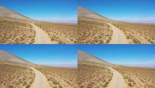 航拍行驶在沙漠土路上的越野车高清在线视频素材下载