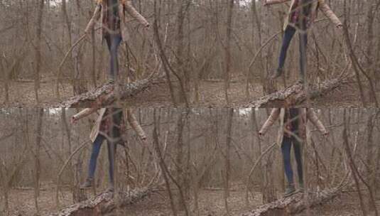 森林里倒下树木上行走的女孩高清在线视频素材下载