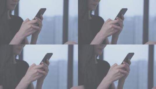 女孩坐在窗边用手机发送消息高清在线视频素材下载