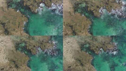 绿松石海水中浮潜游客上空的空中升起，岩石海岸高清在线视频素材下载