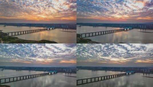 黄昏唯美火烧云下的高铁跨江大桥航拍延时高清在线视频素材下载