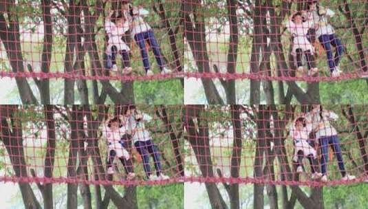 勇敢小女孩系安全带与妈妈高空行走绳网挑战高清在线视频素材下载