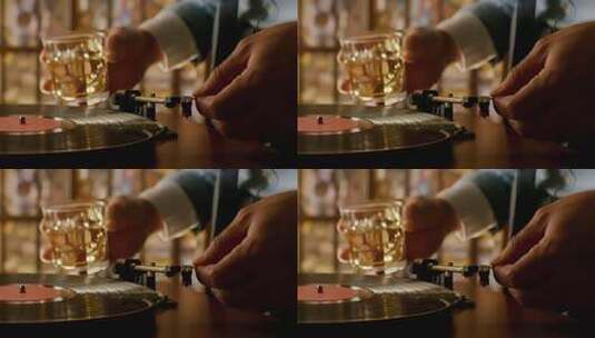人操作唱片机并手持酒杯高清在线视频素材下载