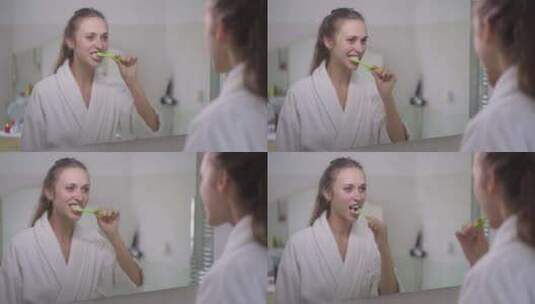年轻苗条黑发白人妇女用牙刷刷牙的镜子里的高清在线视频素材下载