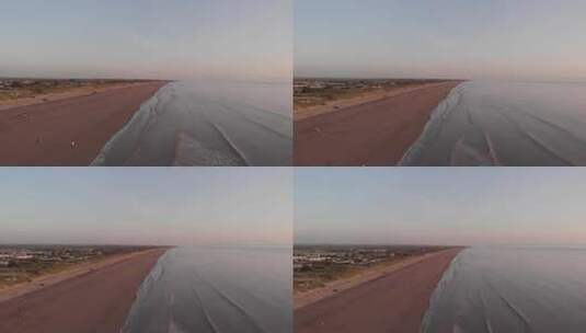 上升无人机拍摄日落时的海滩，潮湿的红沙和日落红波高清在线视频素材下载