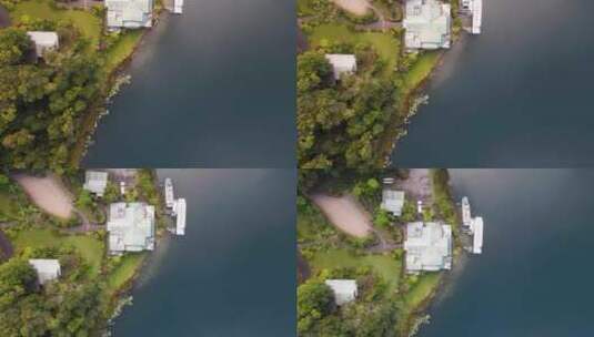 移动无人机视频俯瞰火山口湖旁边郁郁葱葱的公园区域，船只停靠在那里高清在线视频素材下载