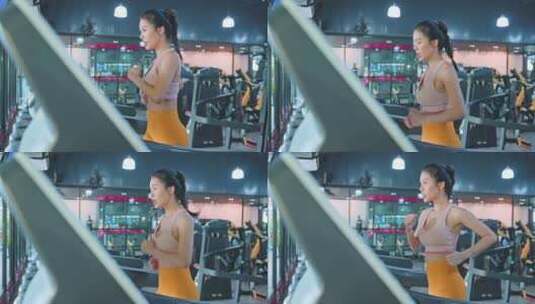 健身房跑步机上穿着运动服跑步的运动女孩高清在线视频素材下载