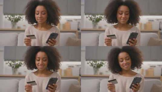 快乐微笑的非裔美国女性手持手机和信用卡购高清在线视频素材下载