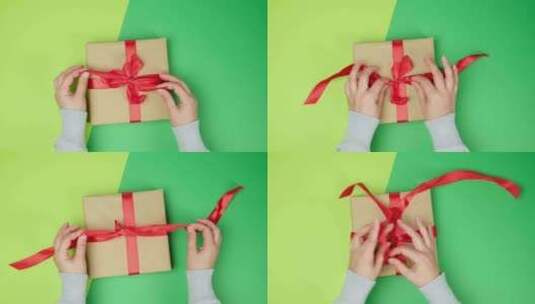 女性手解开礼品盒上的红色丝带，绿色背景高清在线视频素材下载