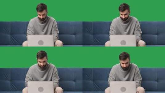 男人远程工作笔记本电脑聊天浏览互联网沙发隔离绿屏色度键高清在线视频素材下载