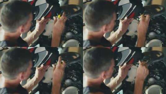 特写镜头一名男性机械师拧开固定摩托车维修高清在线视频素材下载