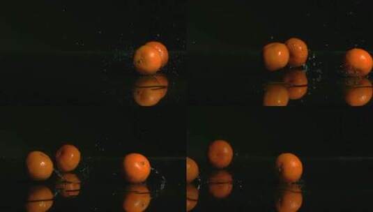 橘子在黑色的水面上弹跳高清在线视频素材下载