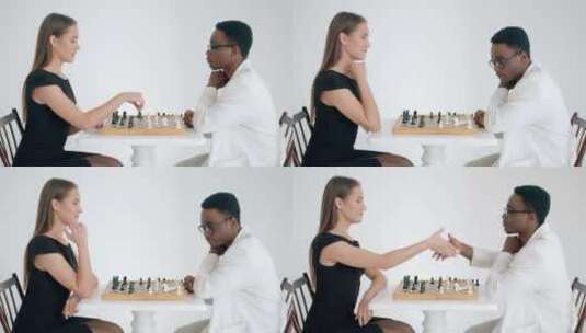 一个高加索女孩在国际象棋中做出赢家的举动，并在国际象棋比赛中与非裔美国人握手高清在线视频素材下载