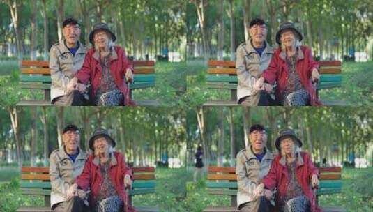幸福的老年夫妇坐在公园长椅上面带笑容聊天高清在线视频素材下载