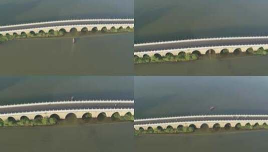 航拍武汉东湖绿道小船穿过桥洞俯拍高清在线视频素材下载