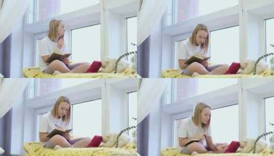 女孩坐在窗台上看着平板学习高清在线视频素材下载