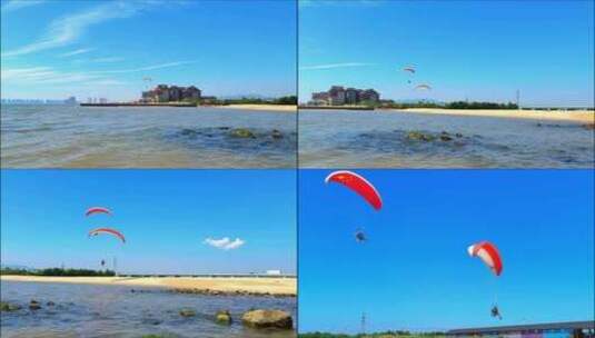 蓝天白云下的海面与海边飞行的滑翔伞高清在线视频素材下载