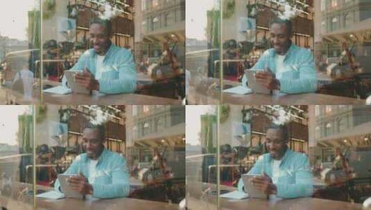 穿着休闲服坐在街上桌子旁的英俊非洲男子在高清在线视频素材下载
