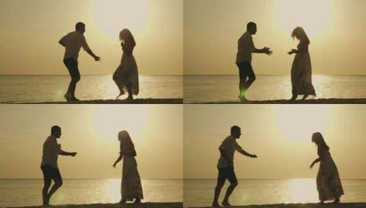 年轻夫妇在大海和落日背景下跳舞的剪影高清在线视频素材下载