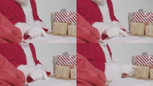 圣诞老人把礼物放进袋里高清在线视频素材下载