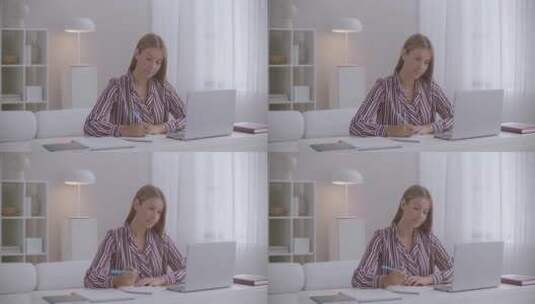 女人坐在电脑前记笔记高清在线视频素材下载