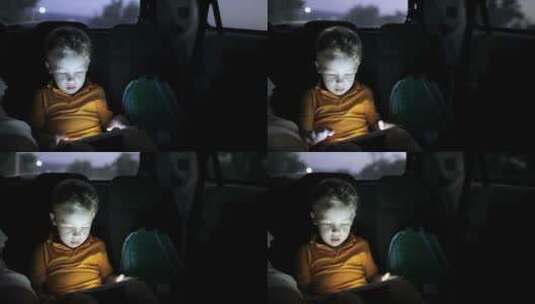 夜里男孩在车上玩平板高清在线视频素材下载