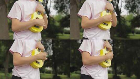 穿着夏装的男孩在公园演奏尤克里里高清在线视频素材下载