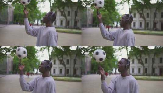 男人戴着耳机在街头用手指旋转足球高清在线视频素材下载