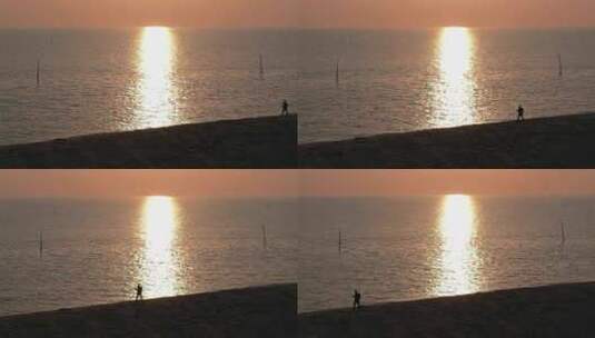 一个人走在夕阳照耀下的沙滩上高清在线视频素材下载