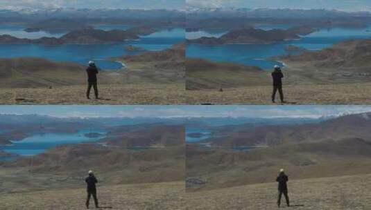 4k男人在航拍西藏蓝色羊湖雪山高清在线视频素材下载