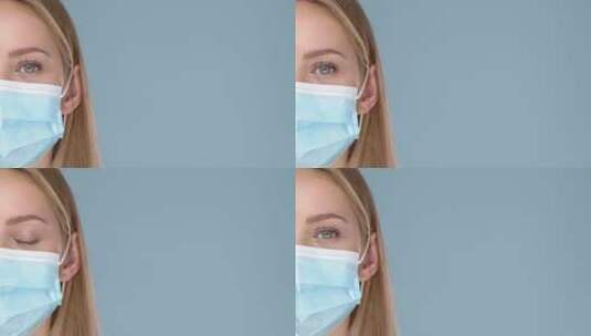 年轻女子戴医用面罩微笑看镜头高清在线视频素材下载