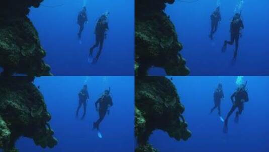 潜水员在礁石旁边游泳高清在线视频素材下载