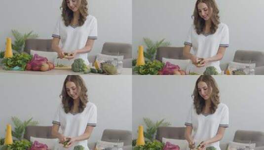 女孩在厨房的桌子旁用刀切黄瓜高清在线视频素材下载