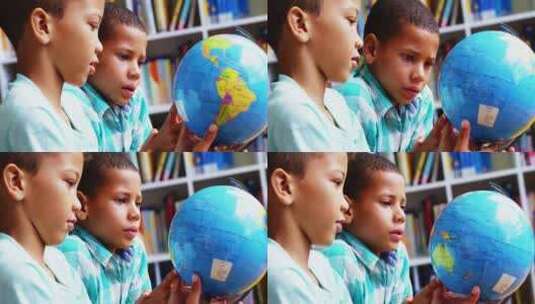 小学生在学校图书馆看地球仪高清在线视频素材下载