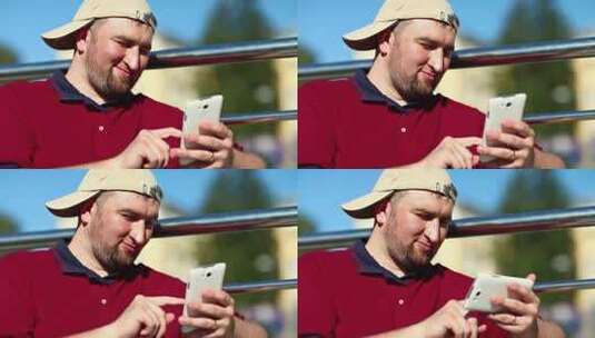 戴棒球帽的男人使用智能手机特写。手里拿着白色手机的胖子高清在线视频素材下载