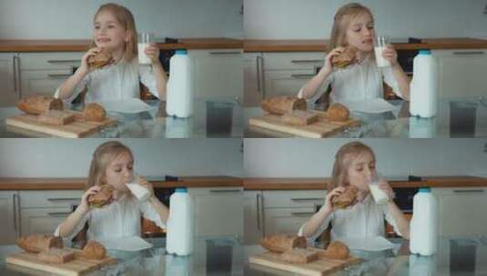 女孩坐在厨房桌子前吃面包喝牛奶高清在线视频素材下载
