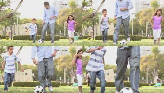 爸爸和孩子一起在公园踢足球高清在线视频素材下载