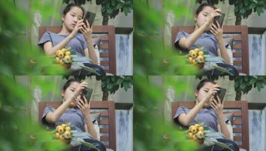 在院子里刷手机的开心漂亮女孩高清在线视频素材下载
