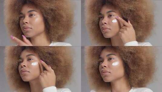 混血黑人女人与大非洲头发在工作室把奶油涂抹高清在线视频素材下载
