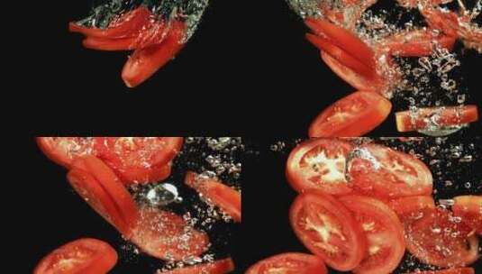 多汁的新鲜番茄片，黑色背景下落入水中高清在线视频素材下载