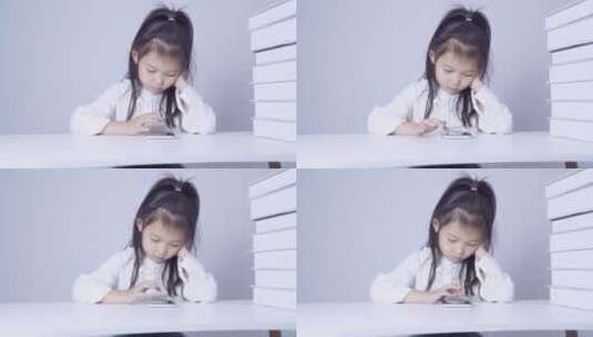 在书桌上使用手机的小女孩高清在线视频素材下载