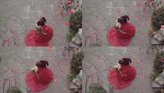 女孩和男孩穿着节日服装在飘落的玫瑰花瓣中站着高清在线视频素材下载