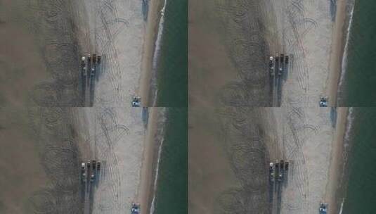 四轮驱动汽车停在海滩上，海浪拍打着海岸线。无人机俯视高清在线视频素材下载