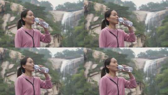 亚洲中国人女性在瀑布下喝水饮用水高清在线视频素材下载
