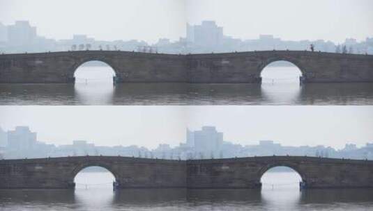 傍晚杭州西湖白堤断桥残雪忙碌的游客高清在线视频素材下载
