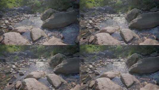 溪流清澈溪水从山间树林石缝流出倒影阳光高清在线视频素材下载
