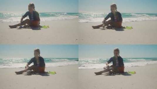 年轻女孩坐着玩沙子高清在线视频素材下载
