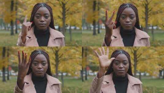 特写镜头严肃专注的非裔美国妇女站在户外看着相机从一个数高清在线视频素材下载