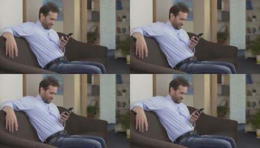 男士在沙发上玩手机高清在线视频素材下载